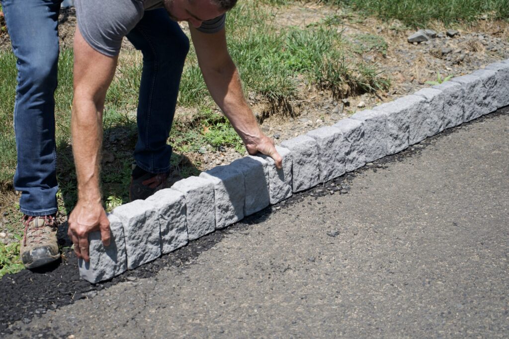 man using precast concrete quikurb to complete a landscaping project